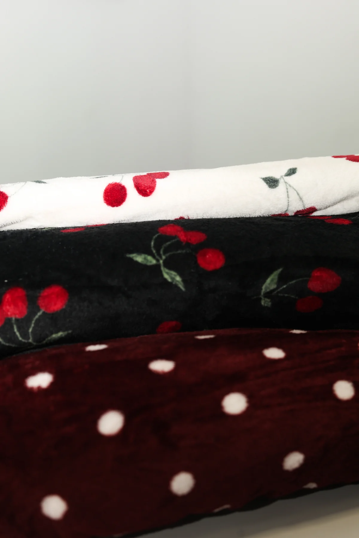 Malha fleece estampada com cerejas em branco e preto, e poá em vinho, com superfície macia